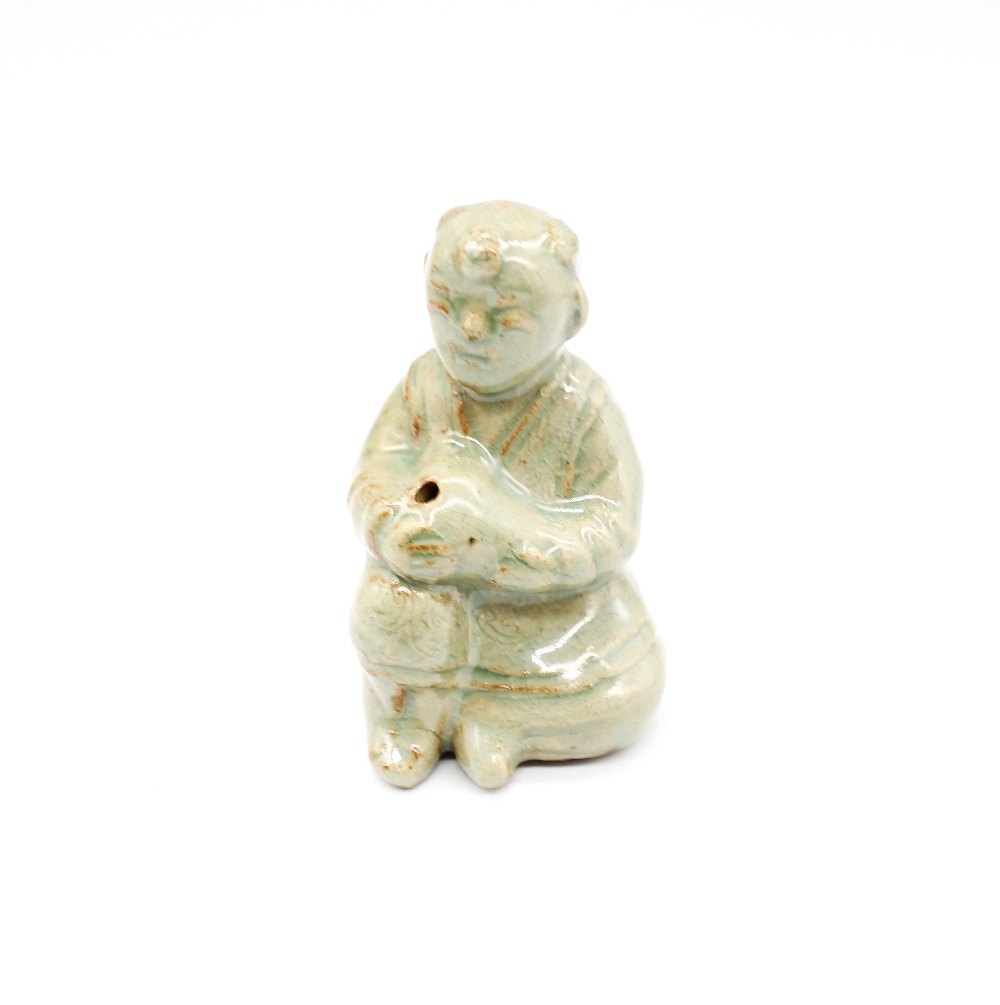 A celadon glazed stoneware human form water dropper with surface iron deposits, style of Goryeo