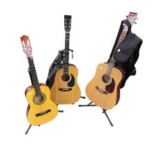 A Burswood acoustic guitar, Hohner and Herold guitars, all on stands, two with carry cases.