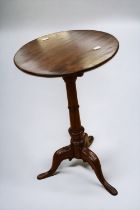 A George III tilt top wine table in oak on tripod legs.