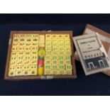 A 20th century cased Mahjong type Chinese game, plastic pieces, with original pamphlet for