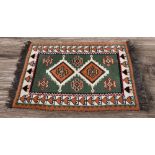 A late 20th Century thick wool hand knotted Afghan rug, green, beige, red black and cream with