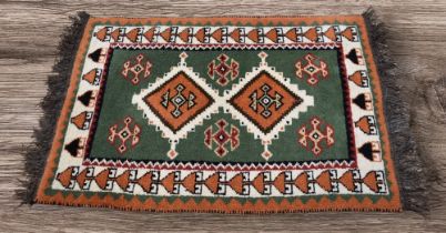 A late 20th Century thick wool hand knotted Afghan rug, green, beige, red black and cream with