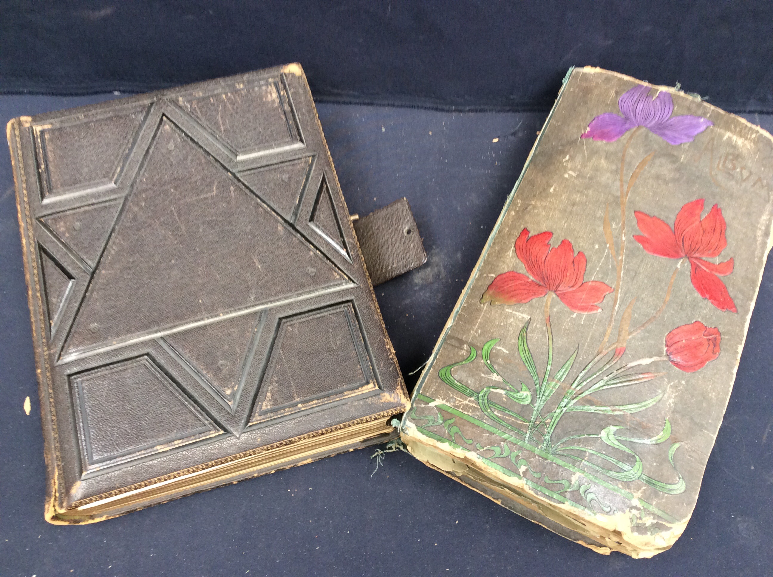 An early 20th century leather-bound photograph album together with a leather-bound postcard album (