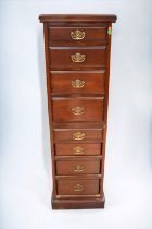 Two part mahogany chest on chest with eight slender drawers and brass swing handles along with a