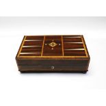 A 19th century veneered games box with inlay, on bun feet and with contents intact.