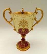 Coalport - A late 19th/early 20th century three handled trophy vase, ornate gilt interior with three