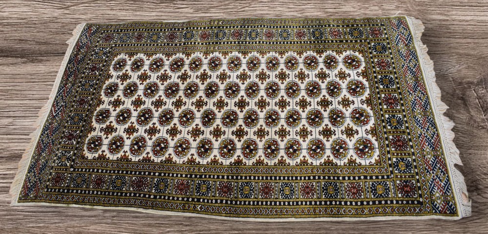 A mid 20th Century hand knotted Afghan rug with medallion and crab detail, cream, green, red and
