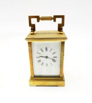 A French brass cased carriage clock with stylised carry handle and roman numeral dial, signed Vokes,