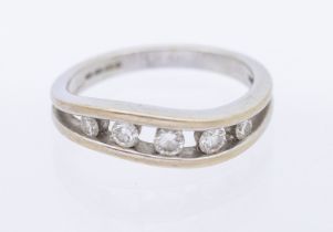 A diamond and 18ct white gold half eternity ring, comprising a wave design channel set with