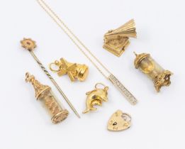 A collection of four 9ct gold charms including windmill, gramophone, dolphin, glass ship in