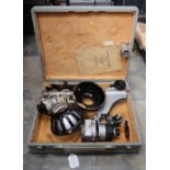 A cased Bell & Howell 16mm projector and empty reels along with a portable photographic enlarger