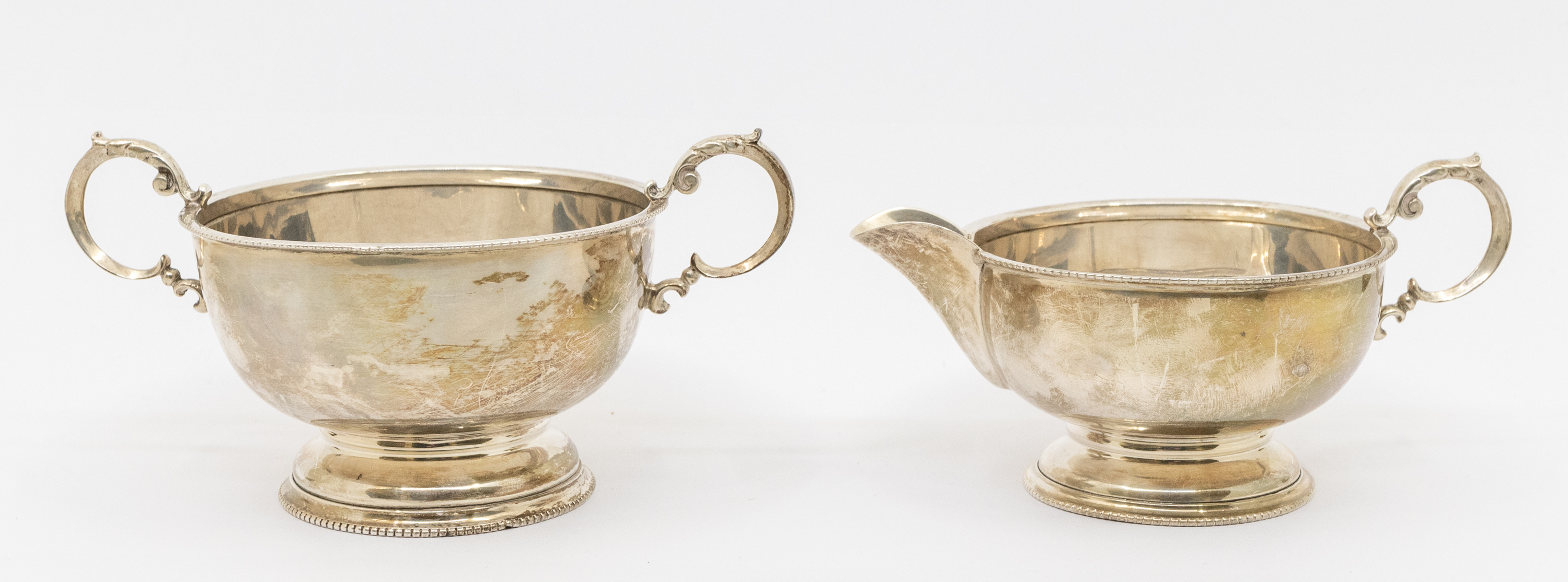 A matching George V silver milk jug and sugar bowl, both with beaded edging and circular footed