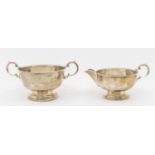 A matching George V silver milk jug and sugar bowl, both with beaded edging and circular footed