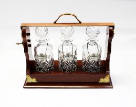 A 20th century three cut glass decanter tantalus, with three Coalport labels for Whisky, Brandy