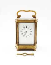 An ornate French brass cased carriage clock, on four circular feet, roman numeral dial, marked