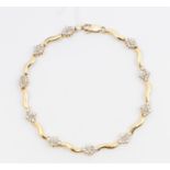 A diamond set 10ct gold bracelet, comprising alternate wave like gold links and grain set diamond