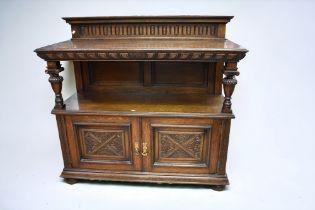 A large Victorian oak buffet with carved supports and two carved base cupboard doors.