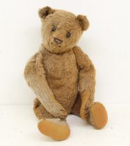 Bear: An early 20th century hump-back teddy bear, with shoe button eyes, pointed, stitched nose,