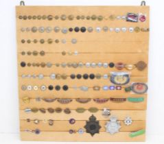 Railwayana: A board of assorted railwayana badges and buttons to include: GWR, LMS, LNER, BR,