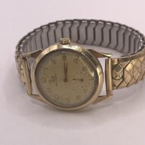 A 1950s 9ct gold Record wristwatch. Featuring a champagne dial with Arabic numerals and subsidiary