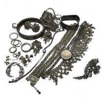 A collection of silver and white metal jewellery. To include a hinged bangle, a locket and rings.