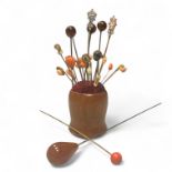 A collection of early 1900s hat pins, on a pin cushion stand, to include lava cameo, micro mosaic