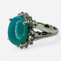 A Chrysocolla and diamond set dress ring. Featuring a central cabochon of chrysocolla measuring