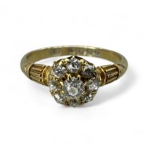 An Edwardian18ct gold diamond daisy cluster ring. Set with nine Old Mine Cut diamonds. the central
