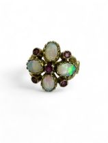An opal and ruby set quatrefoil ring in 9ct yellow gold, with gold scroll work. Size N. Gross weight