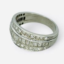 A diamond set dress ring, featuring three rows of diamonds. A line of tapered baguette cut