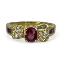 An 18ct gold diamond and ruby set bow ring. Featuring a central 5mm x 4mm oval ruby, at the centre