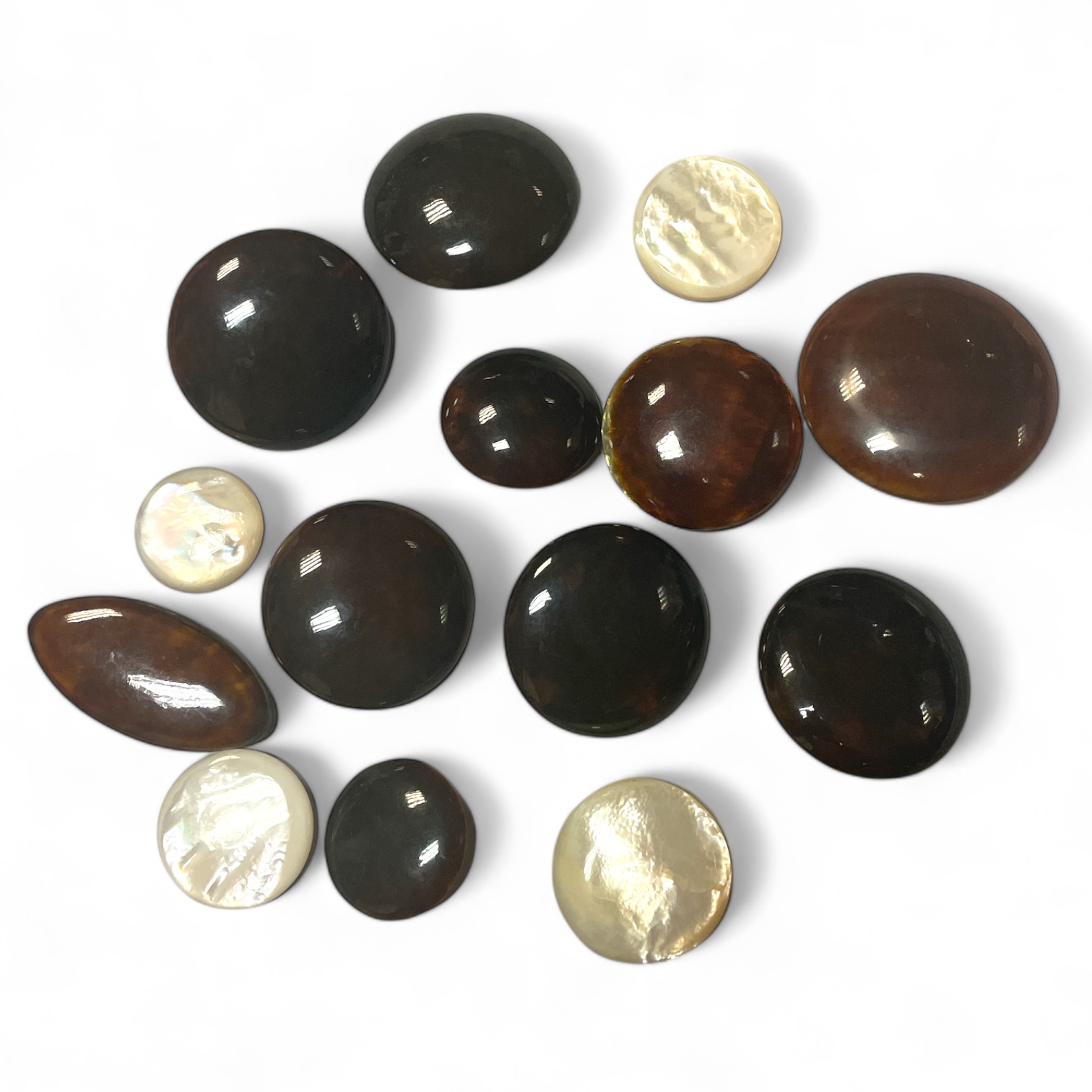 A collection of tortoiseshell and mother of pearl buttons, graduating from 6m to 3cm diameter. 14 in