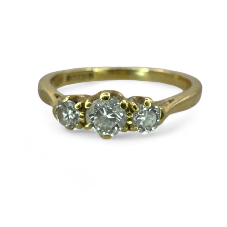 An estimated 0.40ct 18ct gold diamond three stone ring. Featuring a central round brilliant cut