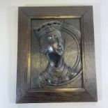 A early oak carved panel of a queens head with a replacement piece and later framed surround 28cm