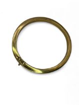 A "9k" stamped hollow hinged bangle, testing as 9K yellow gold. In good condition, free from dents