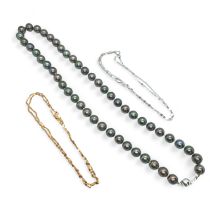A black cultured pearl strand, with a 750 white gold ball clasp, with two 18ct gold chains.