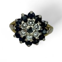 A sapphire and diamond target cluster ring. Set into yellow precious metal testing as 14K gold.