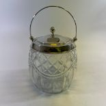 A cut glass biscuit barrel with a silver top, hallmarked Birmingham 1930/31. Approximately 13cm wide