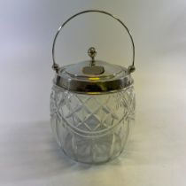 A cut glass biscuit barrel with a silver top, hallmarked Birmingham 1930/31. Approximately 13cm wide