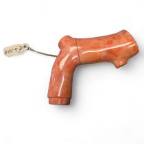 A coral walking cane handle of naturalistic form. Approximate length 7cm. Gross weight of 80