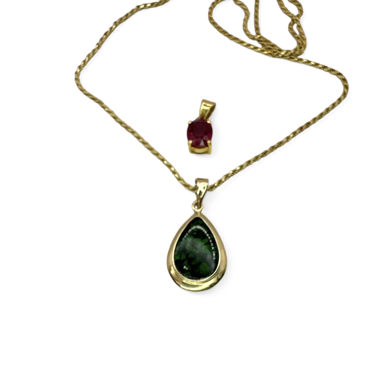 An 18ct yellow gold chain with two pendants, one a flux synthetic ruby stamped 750 and testing as