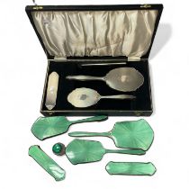 A boxed Silver Back 4 piece dressing set and a 6 piece enamel and silver dressing set (enamel