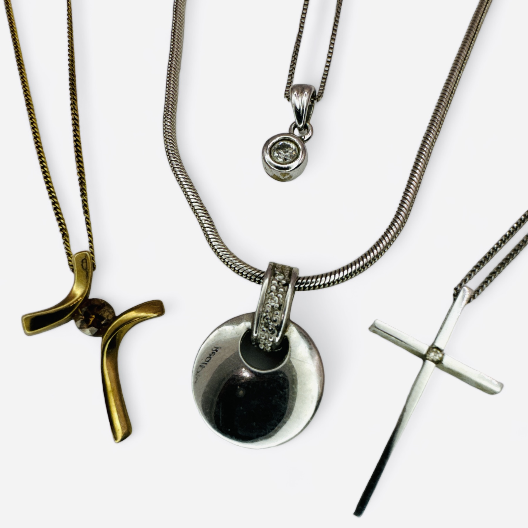 A collection of four 9ct gold diamond set pendants and chains. Featuring a bezel set round brilliant