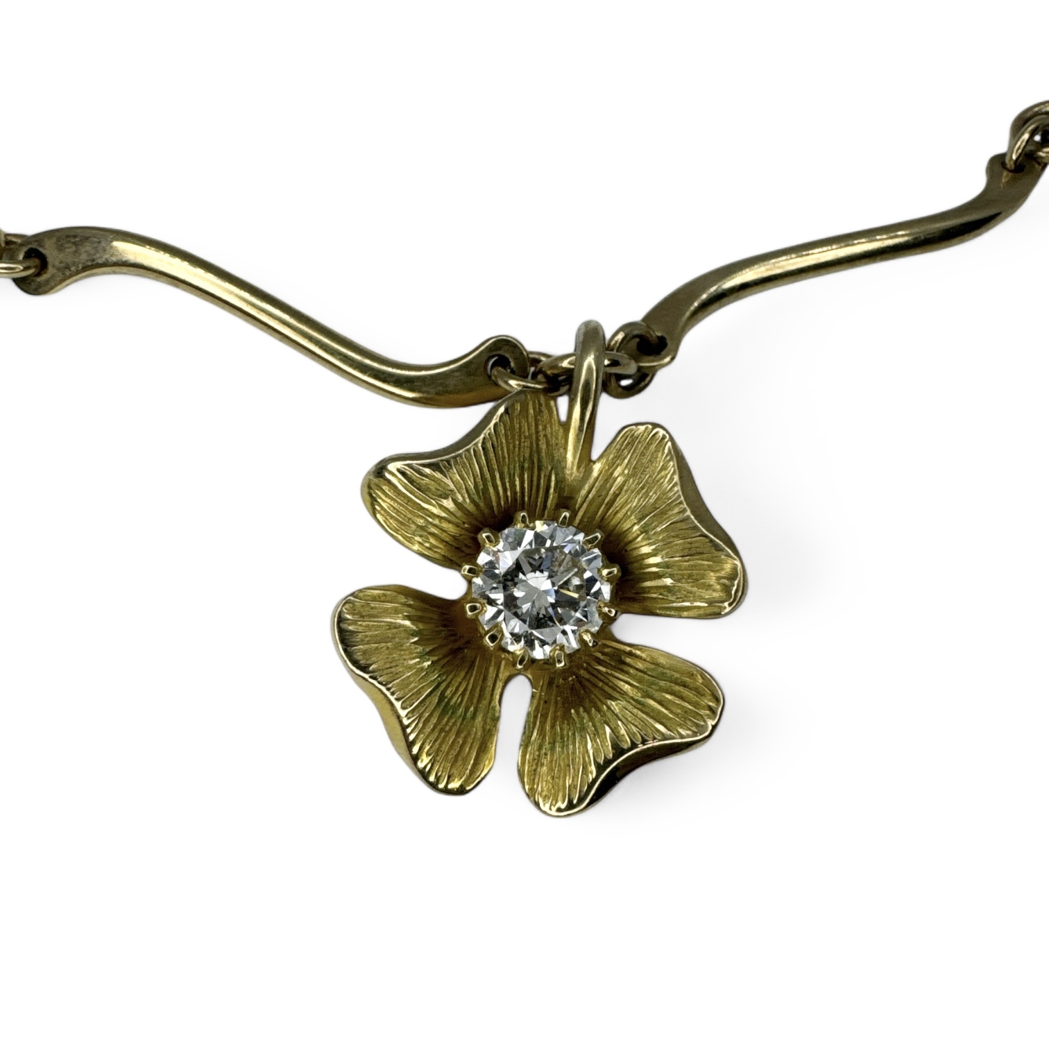 A 9ct gold estimated 0.85 carat diamond set flower pendant on a 9ct gold wave link necklace.