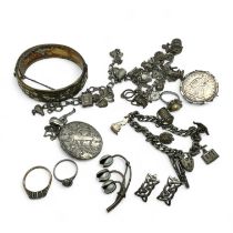 A collection of silver jewellery. Featuring a hinged bangle, earrings, a charm bracelets, an 1891