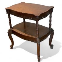 An oak centre table with fretwork frieze and an under tier on splayed supports