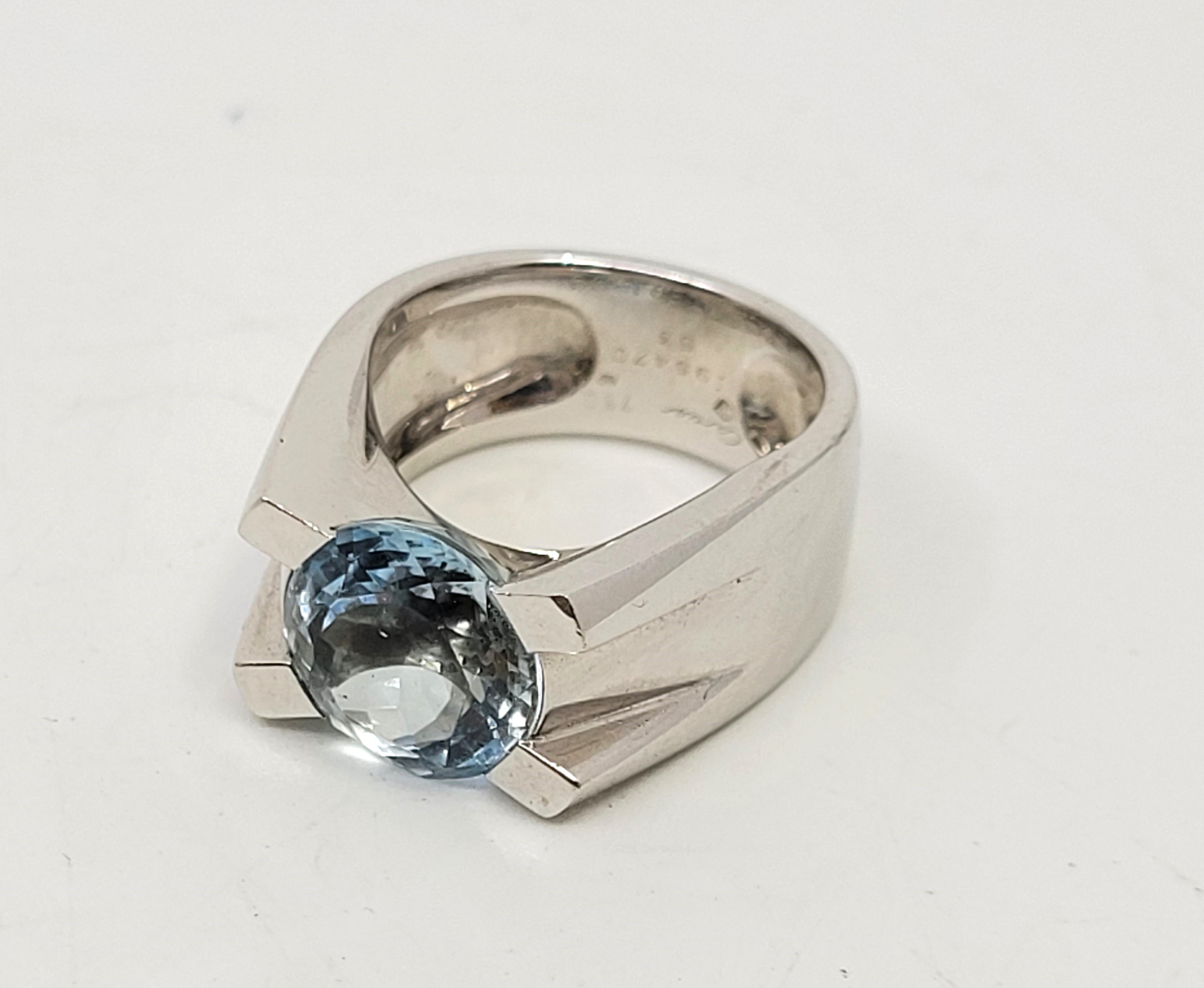 A Cartier 18ct. white gold and aquamarine ring, tension set mixed round cut aquamarine (stone
