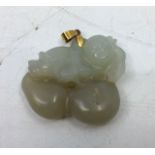A Chinese carved jade pendant depicting peaches