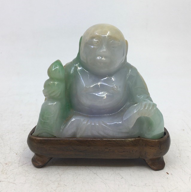 A  Chinese pale green carved jade figure depicting buddha