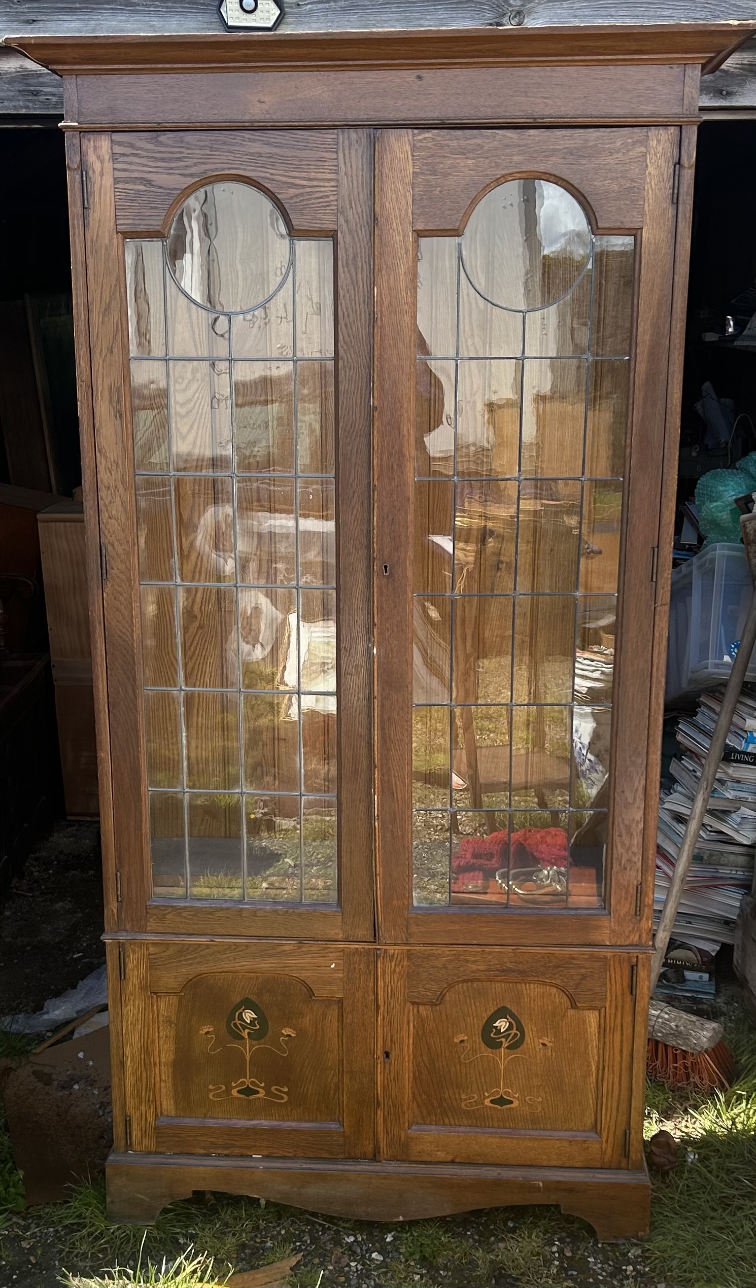 An arts and Crafts attr Liberty glazed cabinet , the twin doors with typical Astral glazed design